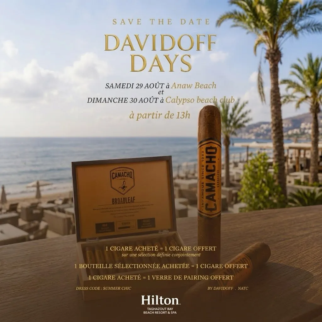 Affiche des Davidoff Days au Hilton Taghazout Bay : un Camacho Broadleaf et son coffret ouvert sur une table en bois, devant la plage et les palmiers.